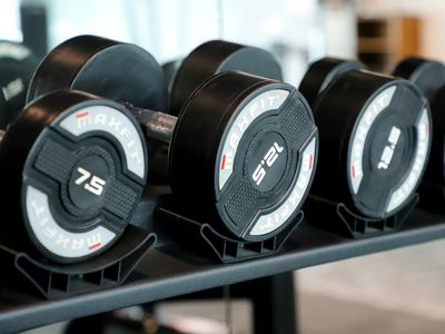 Row of professional dumbbells on a rack in dark gym